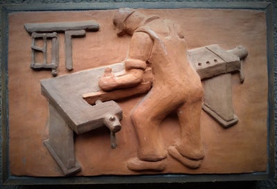 Keramikrelief, motiv: Snedker i arbejde, Relief i keramik af snedker i arbejde.
Indsat i træramme.
D