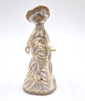 Keramikfigur, Kvinde med kjole og hat. Udført i lyst brændt ler og delvist dækket af hvid glasur med