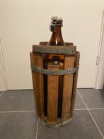 Gammel stor ølflaske med patentprop i træstakit,