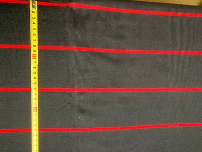 Stof, Fast tæt sort bomuldsstrik med rød stribe. Metervare, stofrest til beklædning. 

Længde 1,6m, 