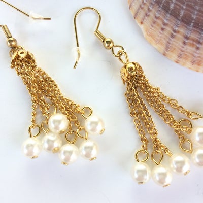 Øreringe, perler, Designer USA, Ferskvandsperler på lange gyldne kæder med forgyldte øreringe.

I al