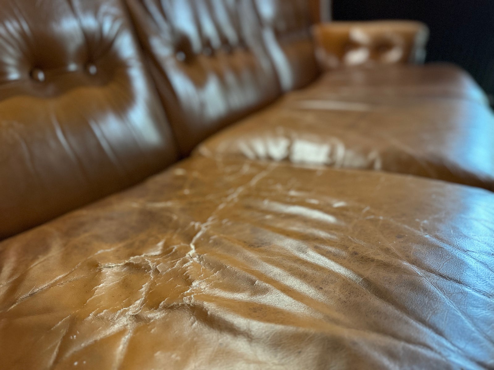 Gyldenbrun lædersofa med negledetaljer