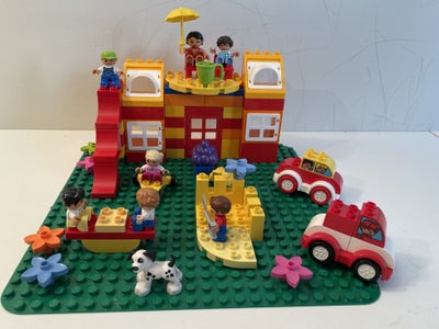 Lego Duplo, Hus med legeplads og parkeringsplads. 
På terrassen sidder der en pige med sin mor, som 