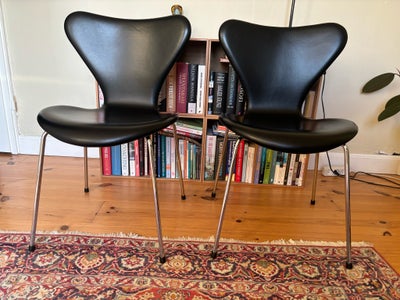 Arne Jacobsen, Syver stol, Spisebordsstol, To Arne Jacobsen spisebordsstole i sort anilinlæder.
Købt