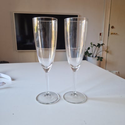 Glas, 2 champagneglas, 22 cm høje, 2 fine champagneglas. 
Måler 22 cm i højden hvoraf 9,5 cm udgør s