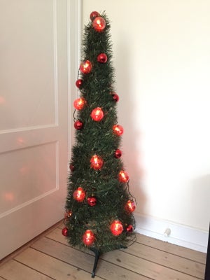 Juletræ på fod og med røde kugler og lyskæde, ca. 120 cm højt.
Den ekstra lyskæde med røde bolde ses