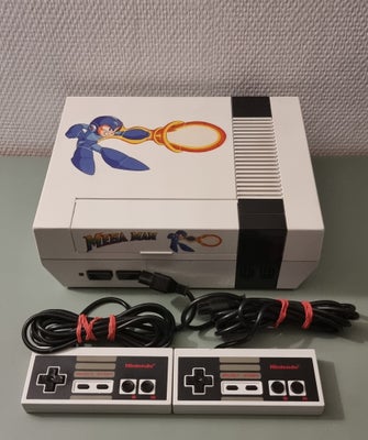Nintendo NES, NES fra Nintendo malet i Mega Man tema. Der medfølger to controllere som ligeledes er 