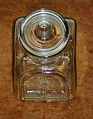 Glas, Krukke / krukker / glaskrukker, Glaskrukke (firkantet) med tætsluttende låg.

Højde: 12 cm.
Om