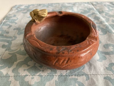 Keramik, Skål, UBRUGT.
Lille skål i ler m. “guldfrø”. Kan evt. bruges til nødder, snacks el. godter.