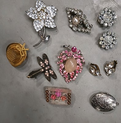 Andet smykke, andet materiale, Ukendt, En samling af forskellige smykker.
Fx flere brocher, to par ø