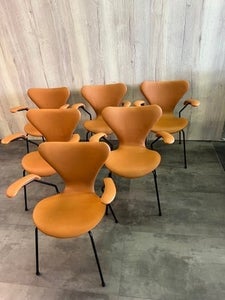 Arne Jacobsen syver stole med armlæn, nypolstret og sort stel. Pris 6 stk